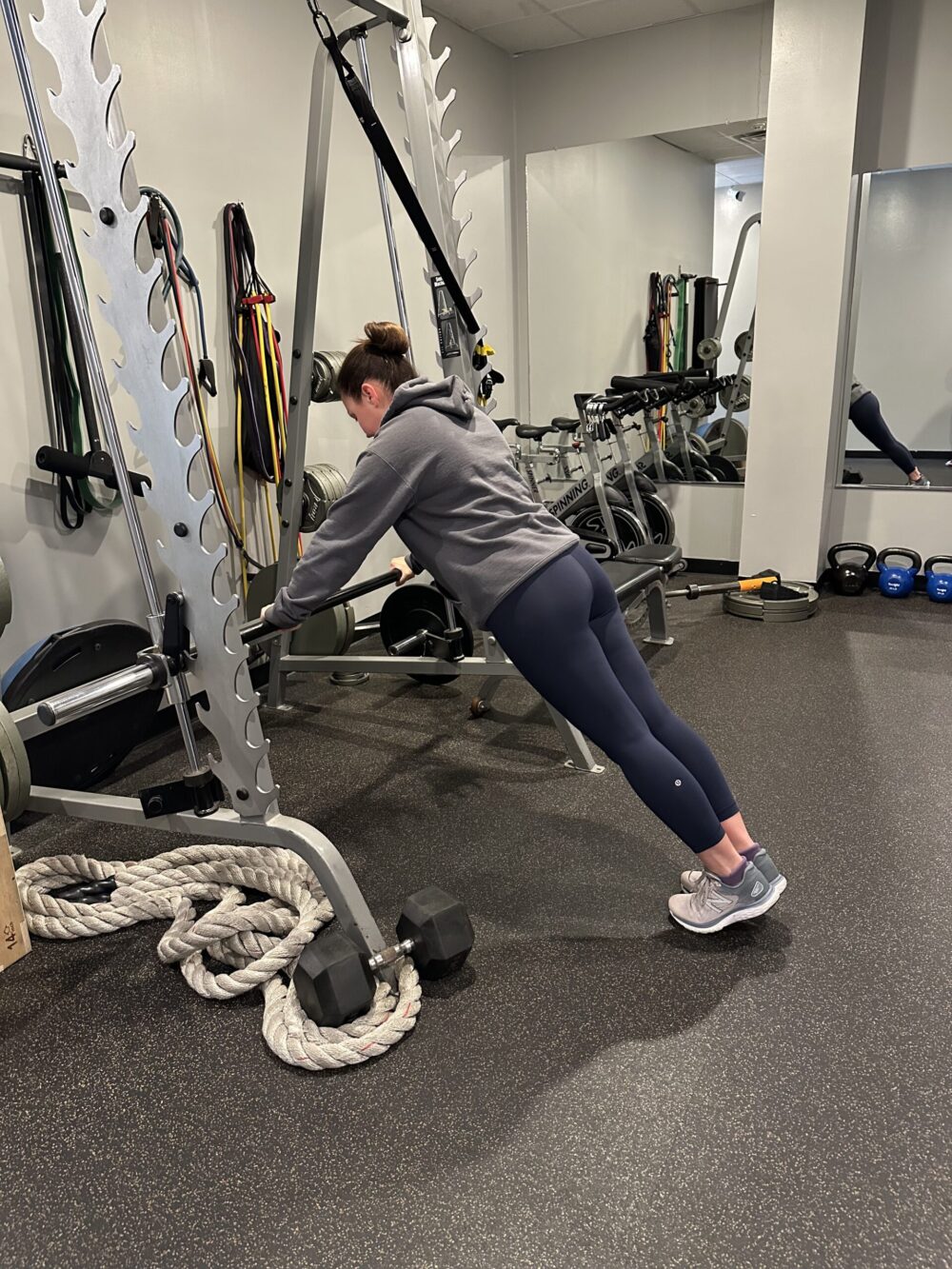 Woman doing incline press in personal training studio.