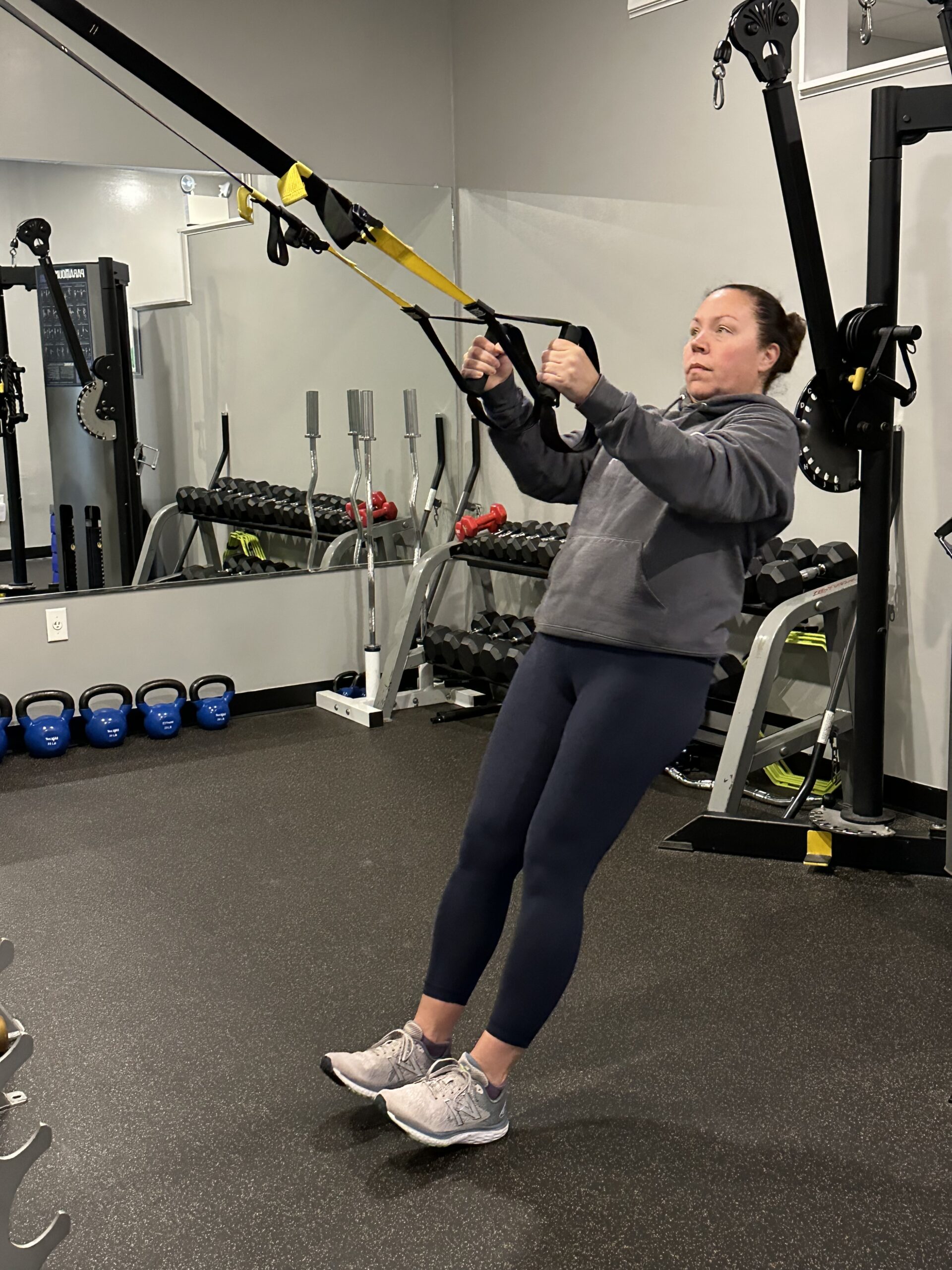 Female personal trainer doing a TRX row