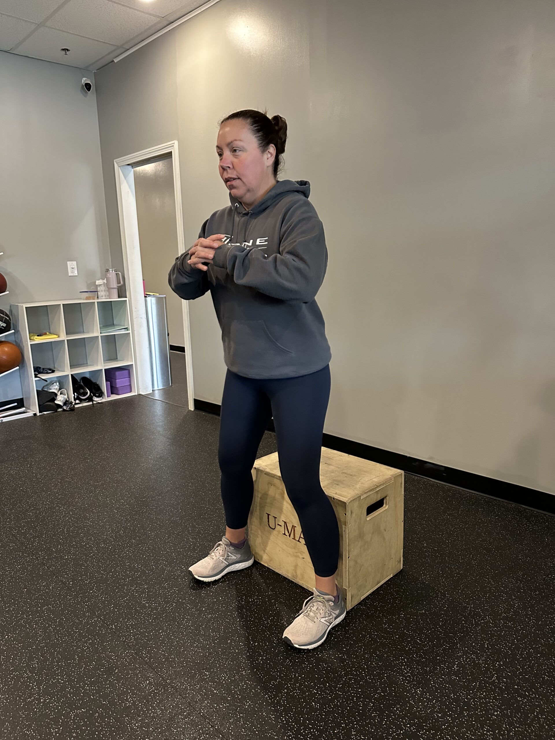 Female personal trainer preparing to do a bodyweight box squat