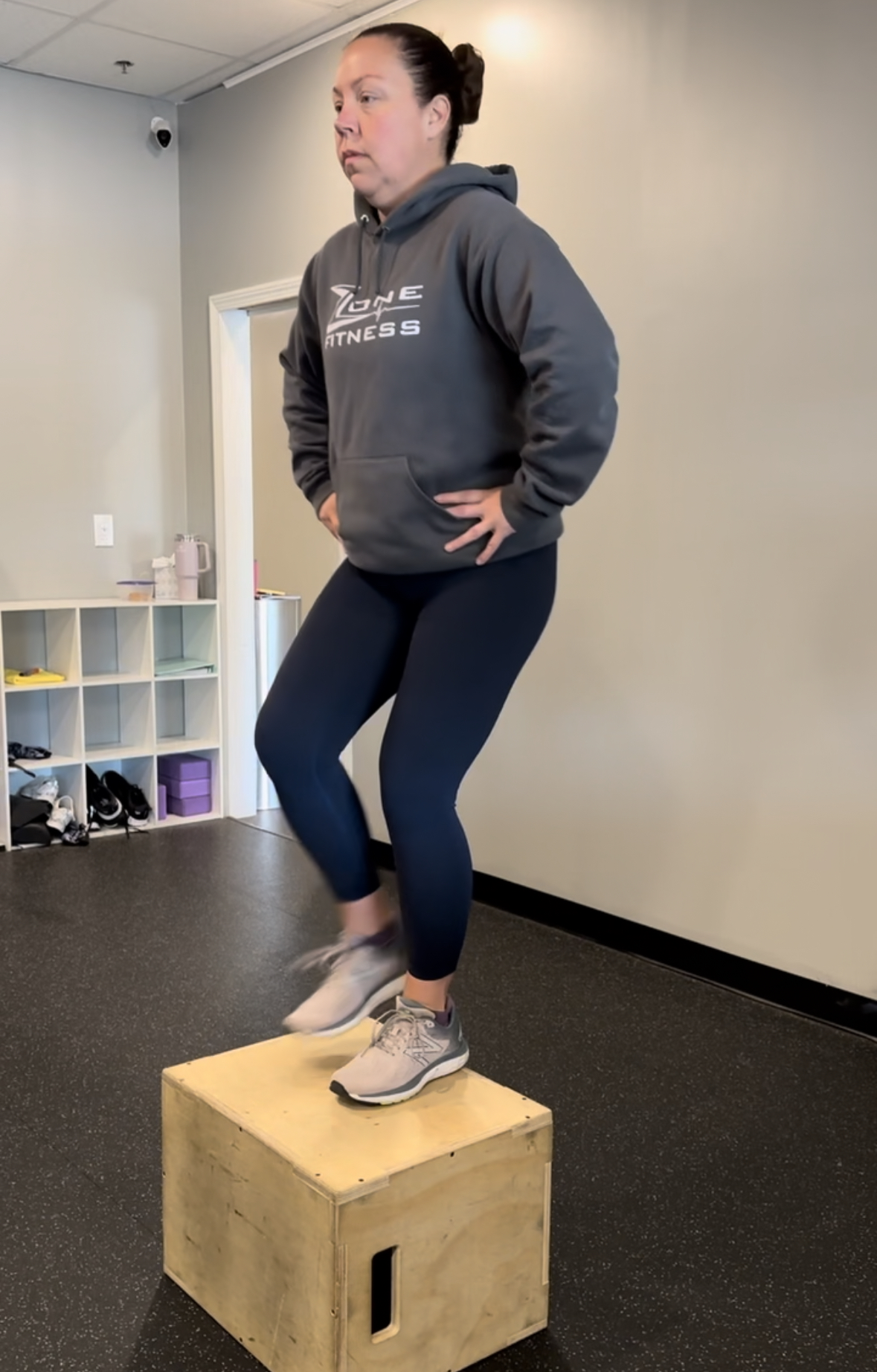 Female personal trainer demonstrating how to do a step up exercise