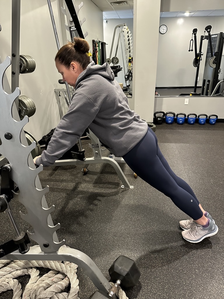 Female personal trainer demonstrating assisted plank.